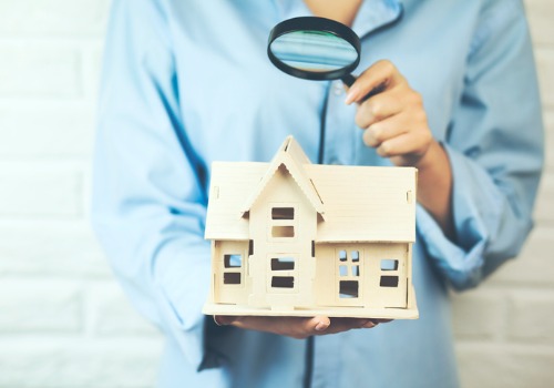 A woman inspecting a model home with a magnifying glass, representative of Public Adjusting in Florida